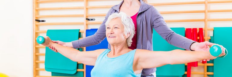 Senior woman in wheel chair doing physical therapy